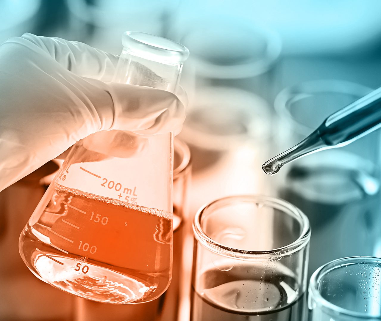scientist dropping the reagent into test tube for reaction testing in chemical laboratory.